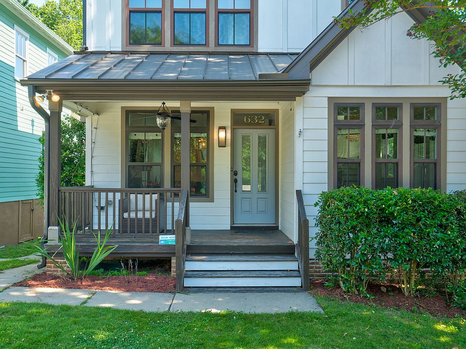 Inviting entry porch has a small front yard with tandem parking for two cars in the driveway with accessible EV charging.