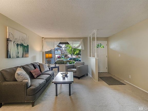 A large picture window in the living room provides ample lighting and a view of the tidy front yard. The entry features tile floor. The home has been updated with white doors and trim.