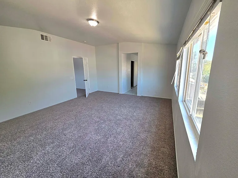 Expansive primary bedroom with abundant natural light and plenty of room for a sitting area.