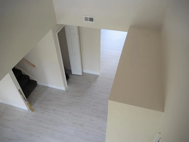 Looking down to foyer and kitchen entry from above. Stairs and storage closet on left and laundry room on right.