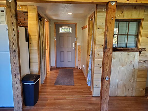 Entry door and hallway with bathroom, bedroom and closet access. Coat hooks on the right and front door has security barrier.