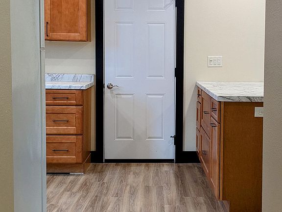 Entryway into kitchen. The door straight leads to storage. The peninsula and living room are to the right.