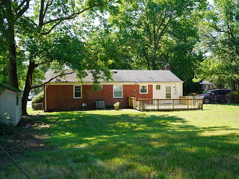 Back of house with huge fenced yard on corner lot with off street parking on the side
