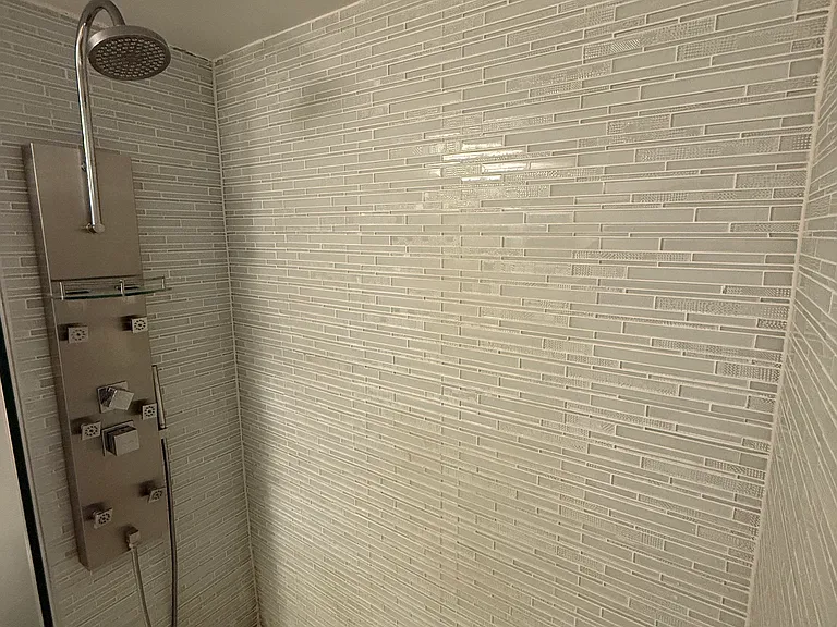 MASTER BATHROOM with limited-edition custom quartz countertop, large vanity mirror, dimmable designer lighting & step-in shower with spa massage jets