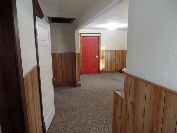 Bright red front door, steel. Looking into living area from bed and bathroom doors.