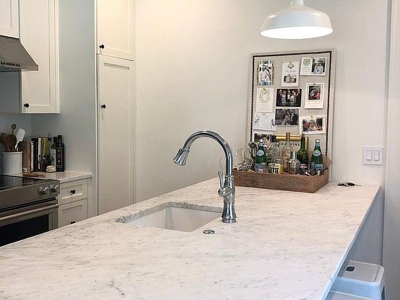 Kitchen has marble counters and stainless appliances.