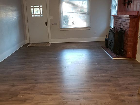 Living room looking toward front door. Fire place works for chilly nights. Flooring is new.