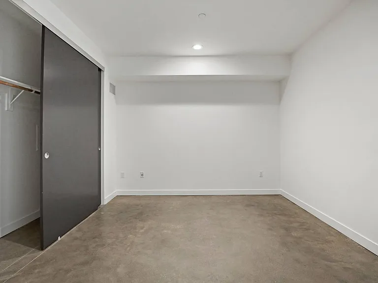 Large-Size Bedroom with Closet, Recessed Lighting, and Concrete Flooring