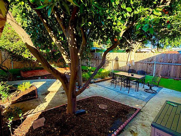 Large backyard with seating area, ample shade, and lush greenery.