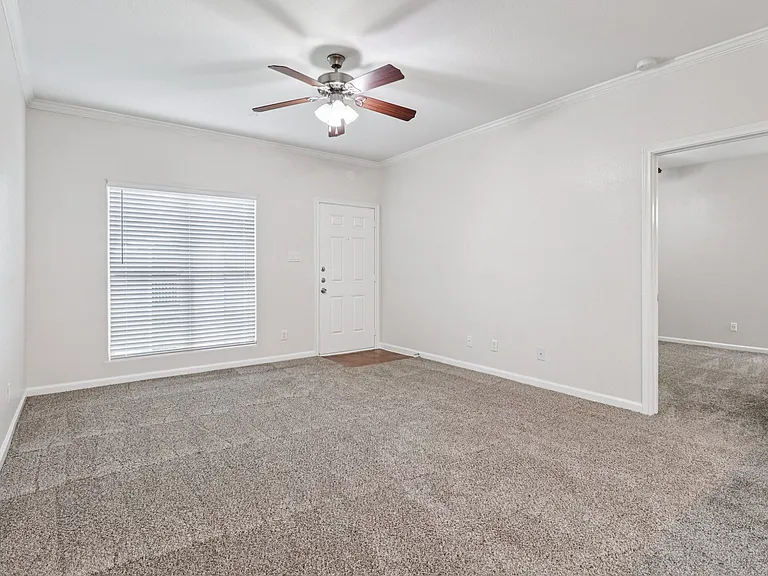 Bright and spacious living room with plush carpeting and modern ceiling fan, perfect for cozy gatherings. Bright and spacious living room with plush carpeting and modern ceiling fan, perfect for cozy gatherings.