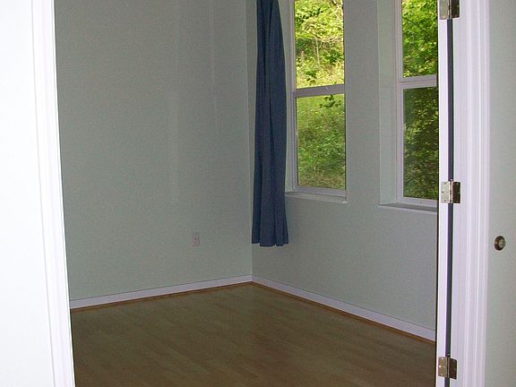 double doors from living room lead into quiet bedroom with large windows