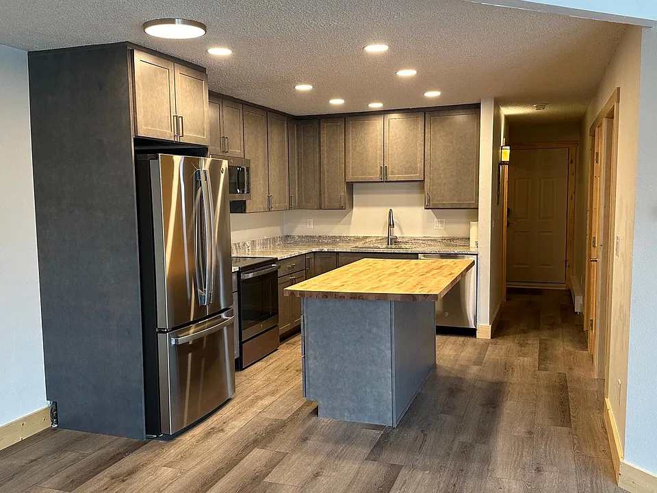 Kitchen with granite and butcher block counters, stainless appliances, soft close cabinets, LED lighting.