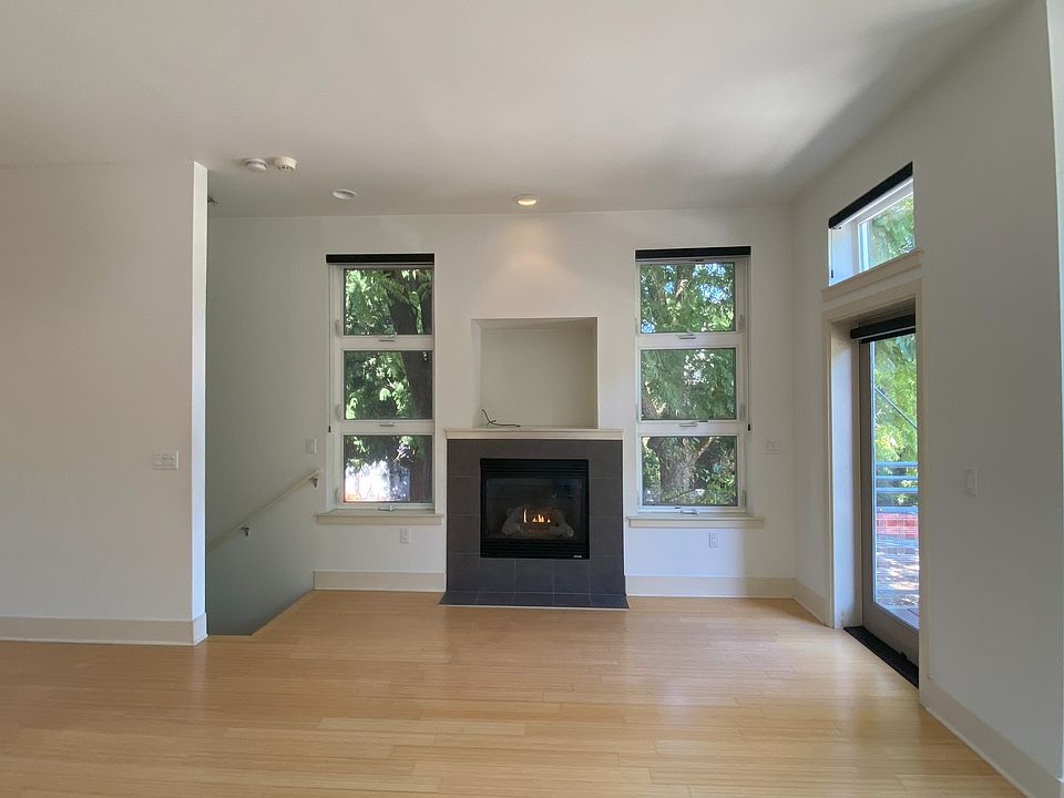 Cozy up around the fireplace surrounded with a view of trees