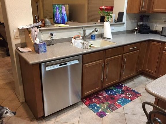 The kitchen has solid-surface (Corian) countertops, recessed LED lights, and is open to the Living/Dining area.