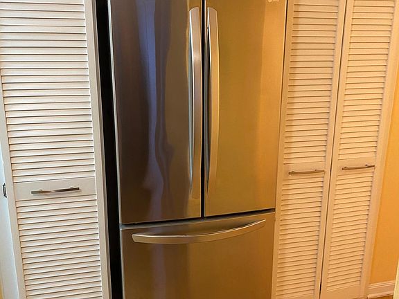 Newer fridge in the hall next to the kitchen + additional storage