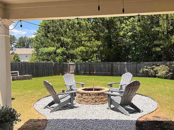 Covered back patio, stone fire pit with lawn chairs