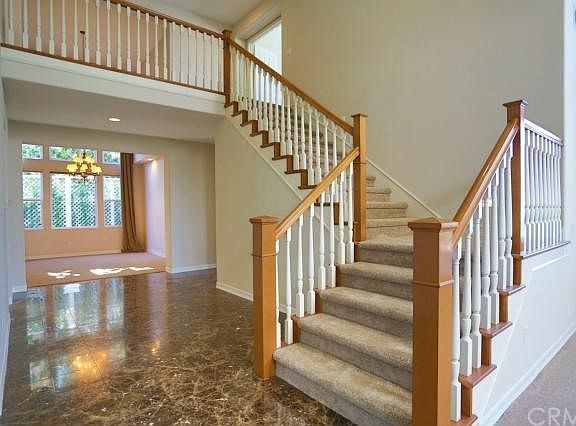 The stairs and hall with marble flooring toward the formal dining room.