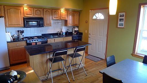 Bright island kitchen with access to deck for grilling.