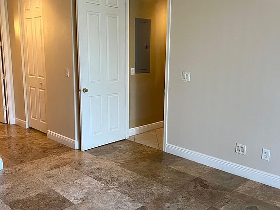 Master bedroom with Travertine Natural Stone floors including in the walk-in closets and fresh new paint including baseboards.