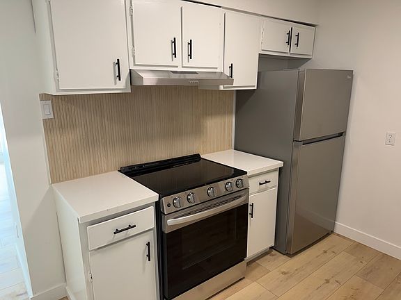 Beautifully remodeled kitchens with quartz countertops with under mount sinks, tiled backsplash, new stainless steel fridge, dishwasher, oven range
