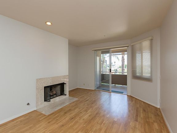 Light and bright living room features hardwood floors, fireplace, freshly painted walls. Sliding gla