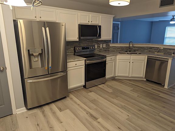 Stainless steel appliances, including a dishwasher and microwave, and designer backsplash and countertops