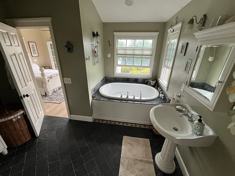 Jacuzzi tub overlooking lush garden below.