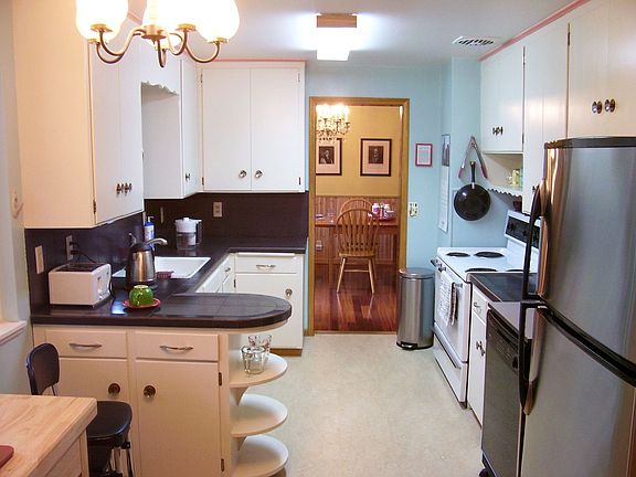 Kitchen has porcelain counters, new refrigerator, refinished cabinets.
