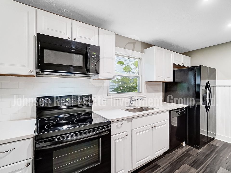 Stunning remodeled kitchen with black appliances and white quartz countertops!