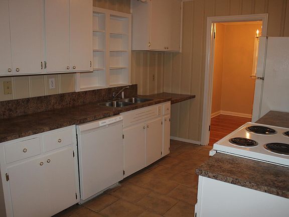 Brand new dishwasher in kitchen with hard tile floor.