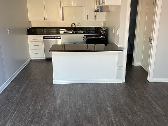 kitchen and hallway leading to half bathroom