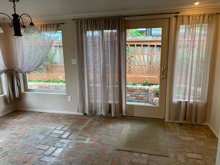 Sun Room/dining area with french doors leading into private fenced backyard, surround sound speakers, brick flooring and lots of lighting. Enjoy your meals surrounded by nature