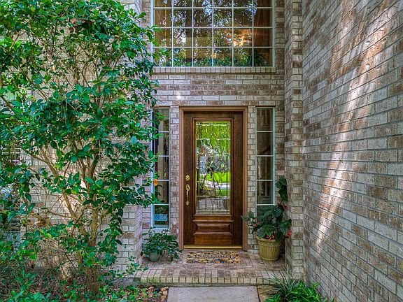 Entry has a lovely leaded glass door, 2-story entry, decorative arches and tile floors