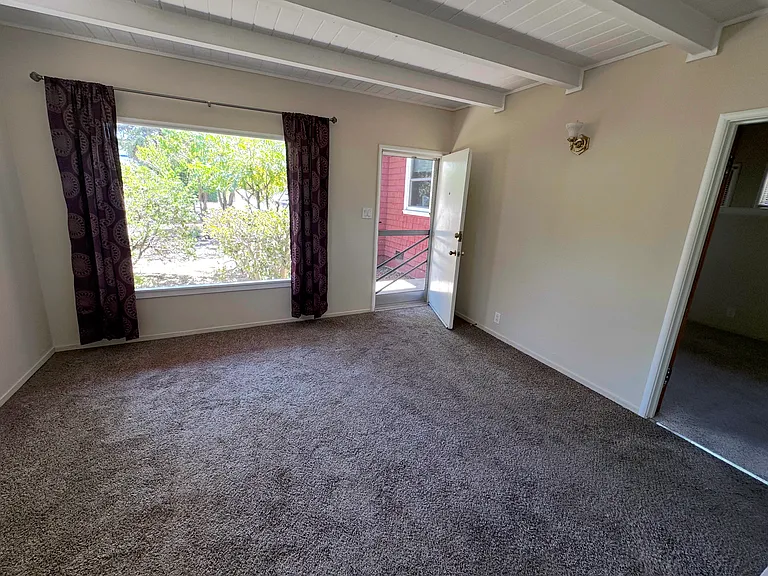 Living room with the front door (middle) and the bedroom door to the right