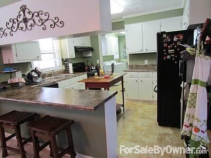 Kitchen
						:
						Kitchen, with an eat-in bar, opens into the den. Laundry is off the kitchen.