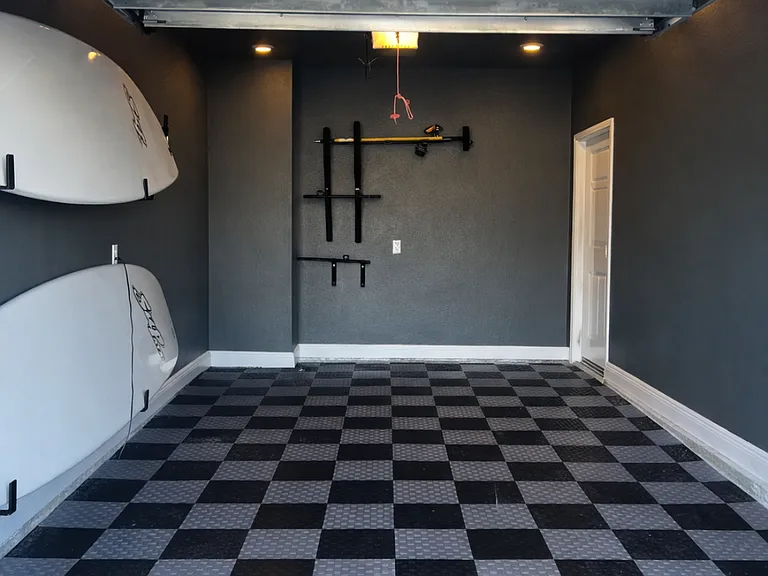 Custom flooring in the garage with paddle board racks, bike racks, and storage racks overhead. Can park car inside