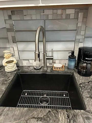 Extra deep composite stone sink. High end faucet with retractable sprayer. Garbage disposal. Custom glass tile and glass accent tile.