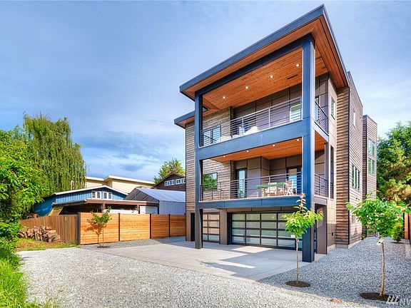 Back-side and beautiful with decks and outdoor dining and lounging galore.  Oversized 3-car garage for lots of toys.