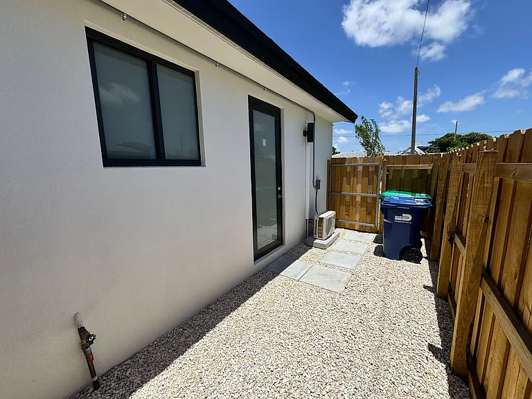 Fenced side yard with gravel landscaping, stepping-stone walkway, and a private exterior entry for easy access.