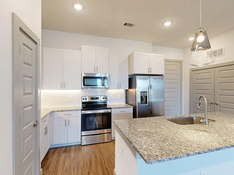 Apartment Kitchen with granite counter tops and Wood-Style Flooring.