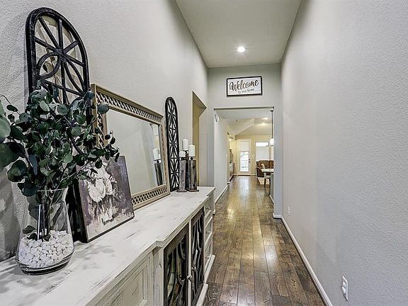 You will enter through the etched glass door into the long hallway with laminate wood floors, neutral paint and tall ceiling.