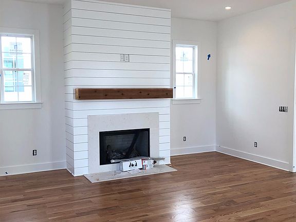 Spacious living room with gas log fire place, lots of light and open to kitchen dining area.