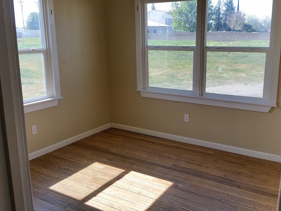 Bedroom windows offer lots of light. Wood blinds and drapes offer privacy and darkness for sleeping.