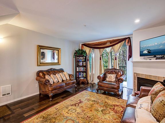 Open living room with gas fireplace and beautiful laminate floors access to private deck area.