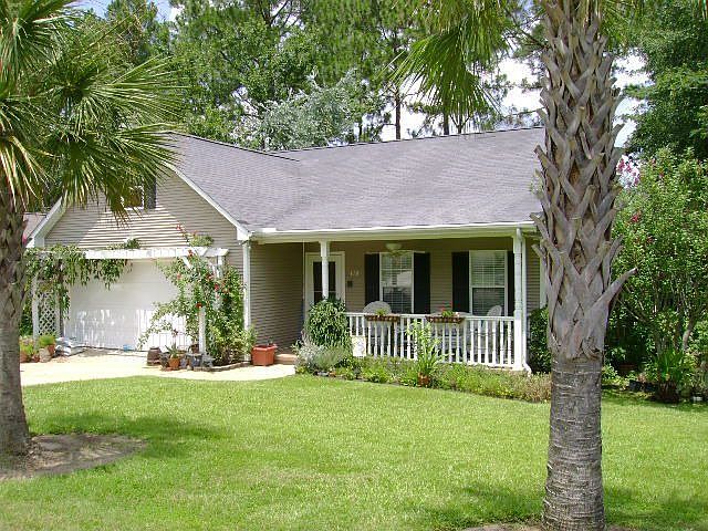 Mature Landscaping front and rear of home with pergola at garage and side yard