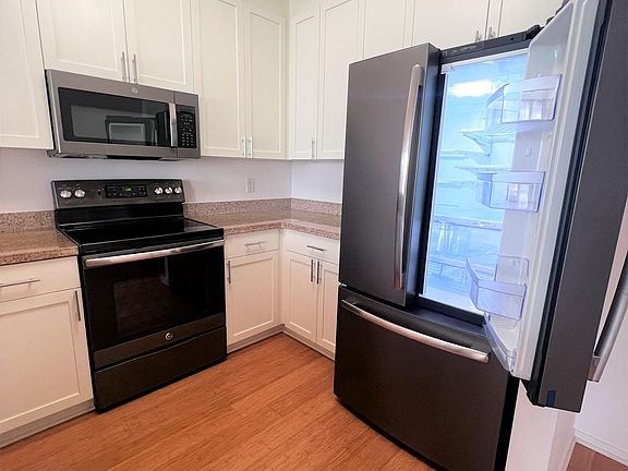 Kitchen with stove, microwave, fridge, dishwasher, gargage disposal and pull down sink faucet