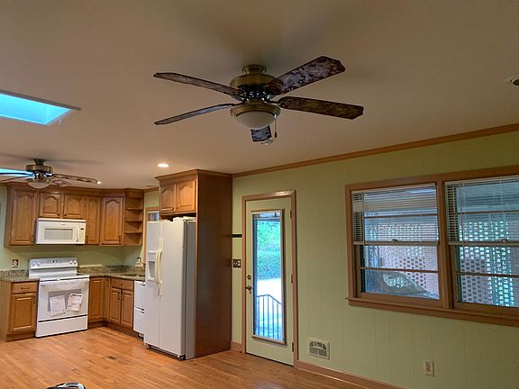 Back entrance to kitchen & family room from utility & carport. Door blinds between glasses. Sky light and ceiling fans