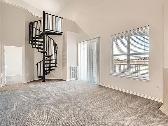 A Living Room with a Spiral Staircase at Fox Run Lofts