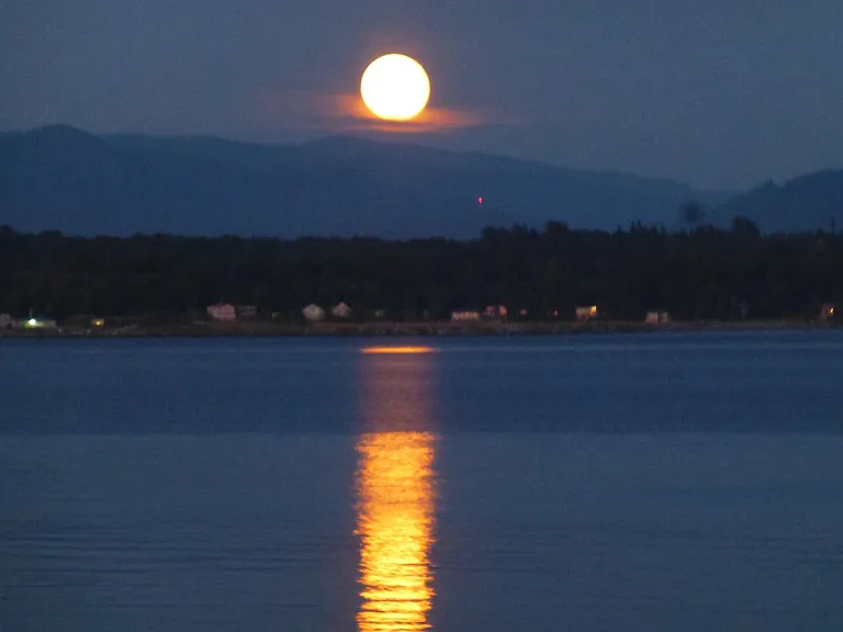 Moon rising behind Cascades over the bay.