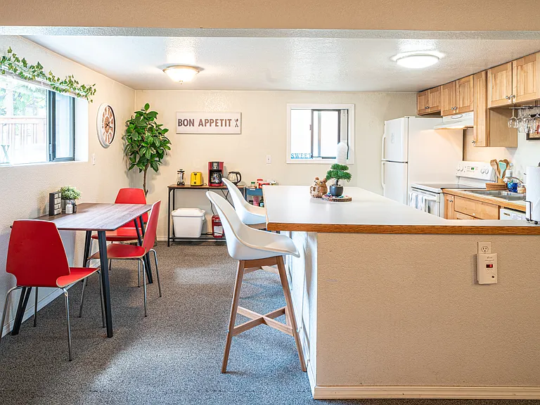 Fully equipped, cozy kitchen with a large island, a coffee bar and a set of dining table and chair.